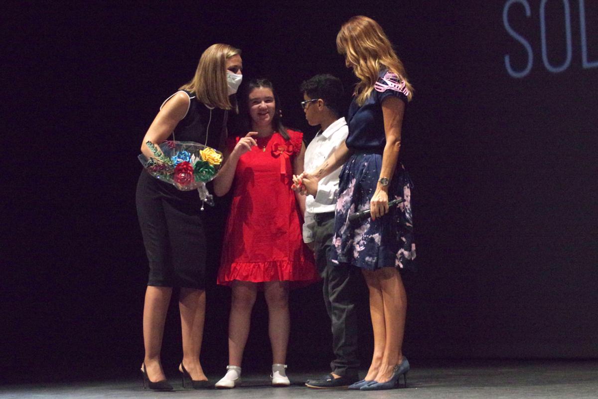 Maribel Sánchez charla con Rocío García Fernández y Amine Nouri Daoudi, los niños afiliados que le regalaron un ramo de flores de papel hecho por chicos con discapacidad.