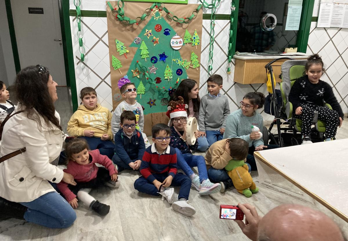 Niños y niñas alrededor de su árbol para celebrar la Navidad