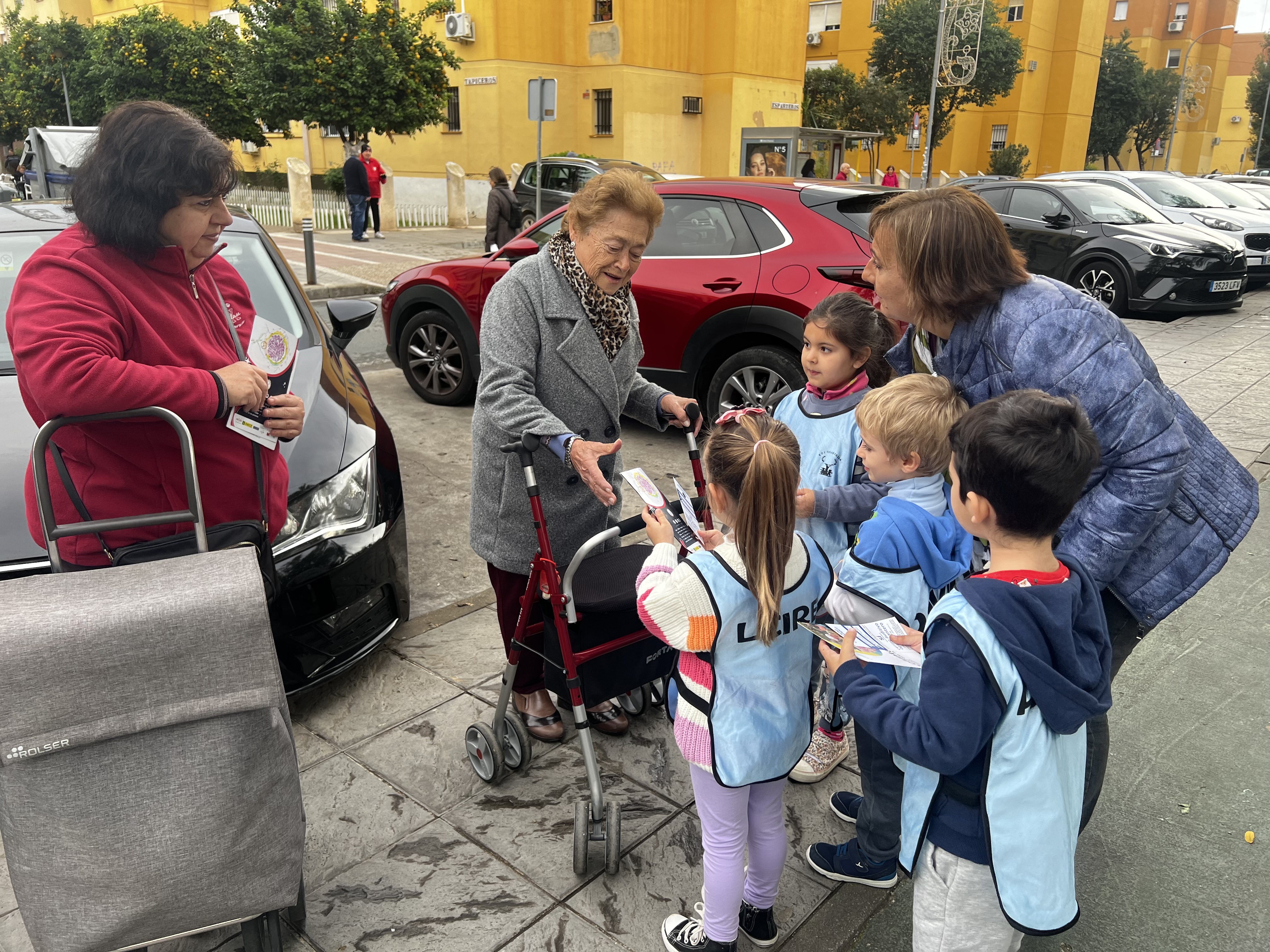 Niños entregando dípticos a vecinas del barrio de Pino Montano