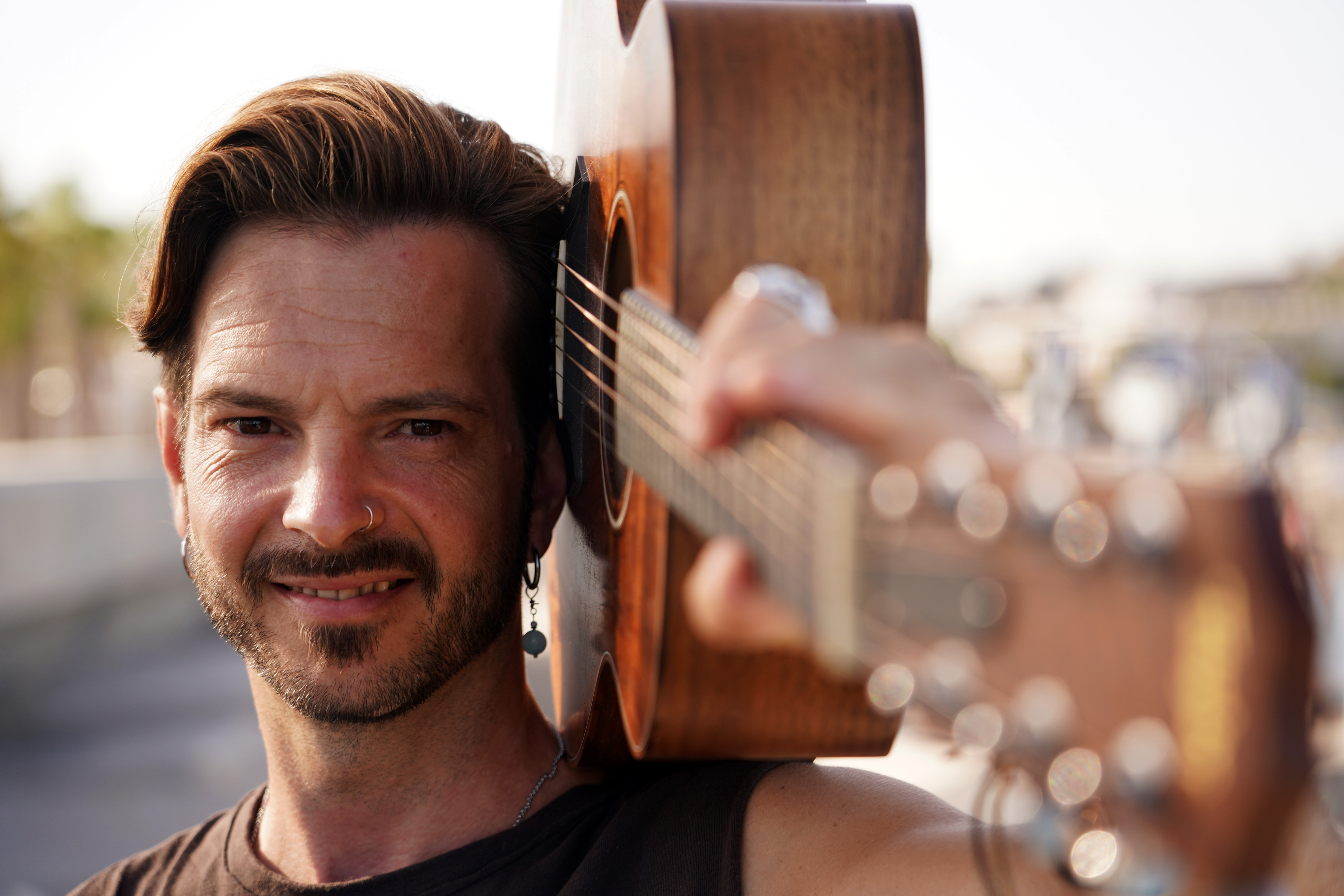 Primer plano de Joaquín sonriente con su guitarra al hombro