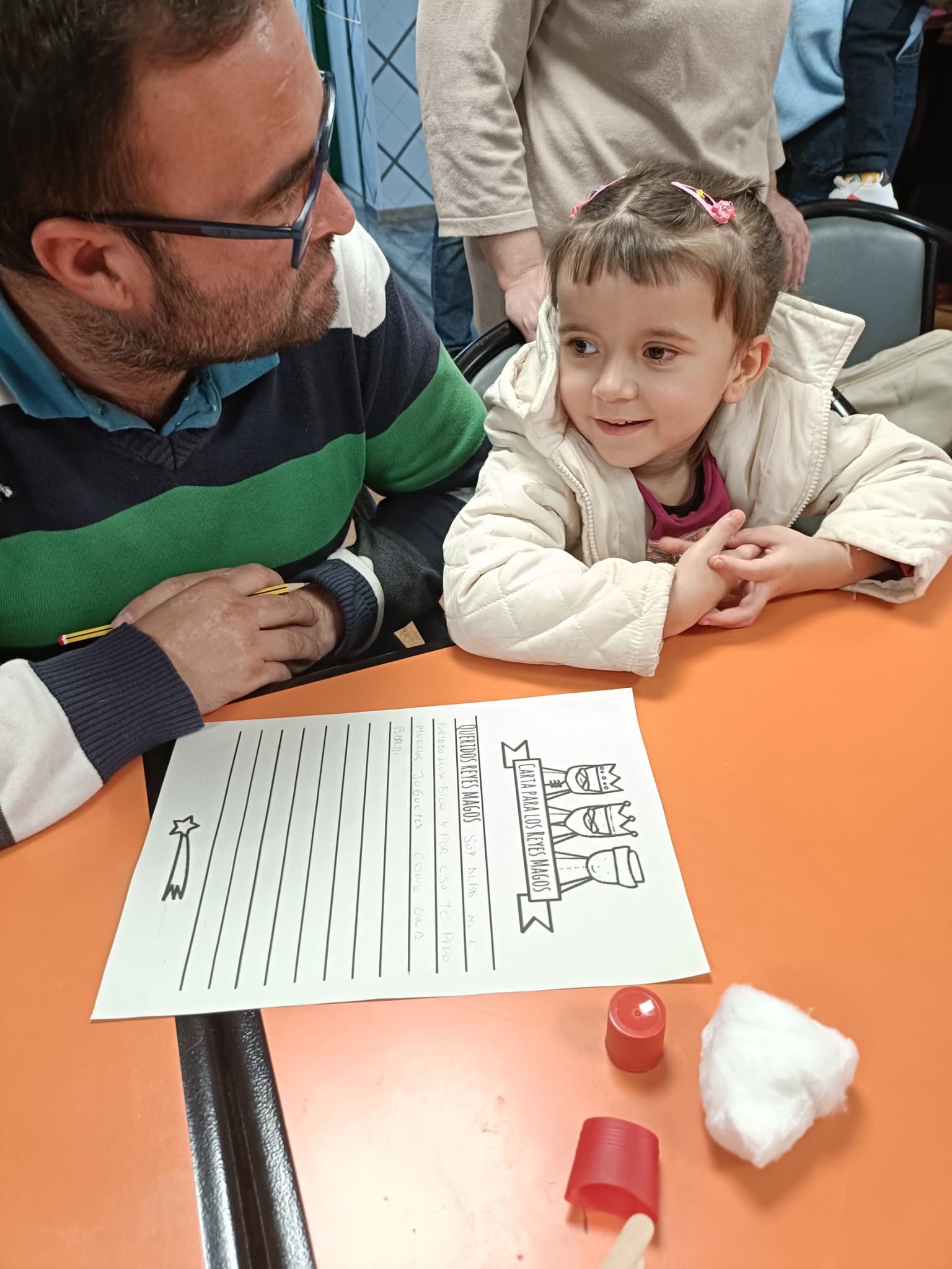Alumna escribiendo la Carta de los Reyes con la ayuda de su padre