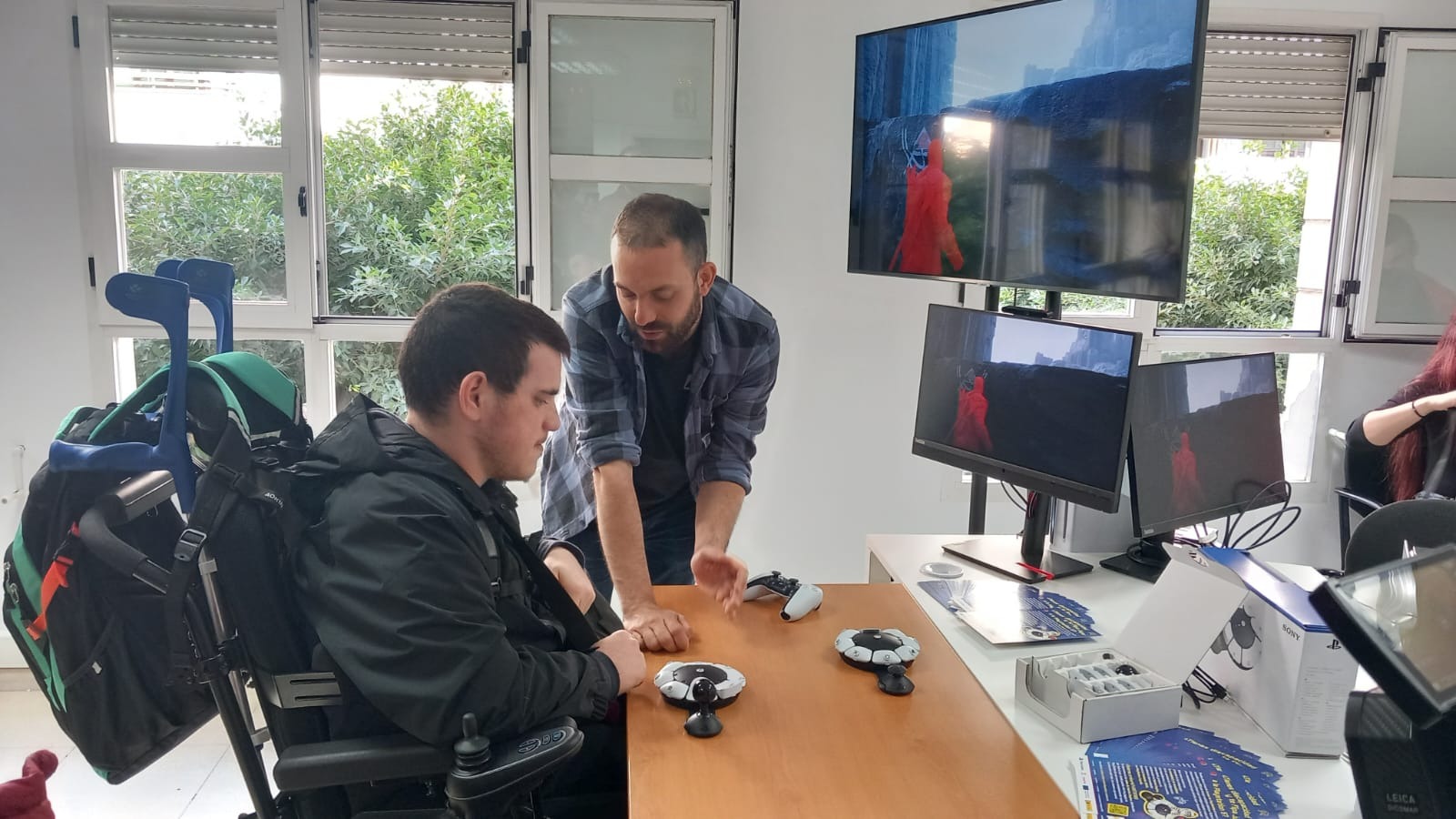 usuario en silla de ruedas aprendiendo a manejar el nuevo mando accesible