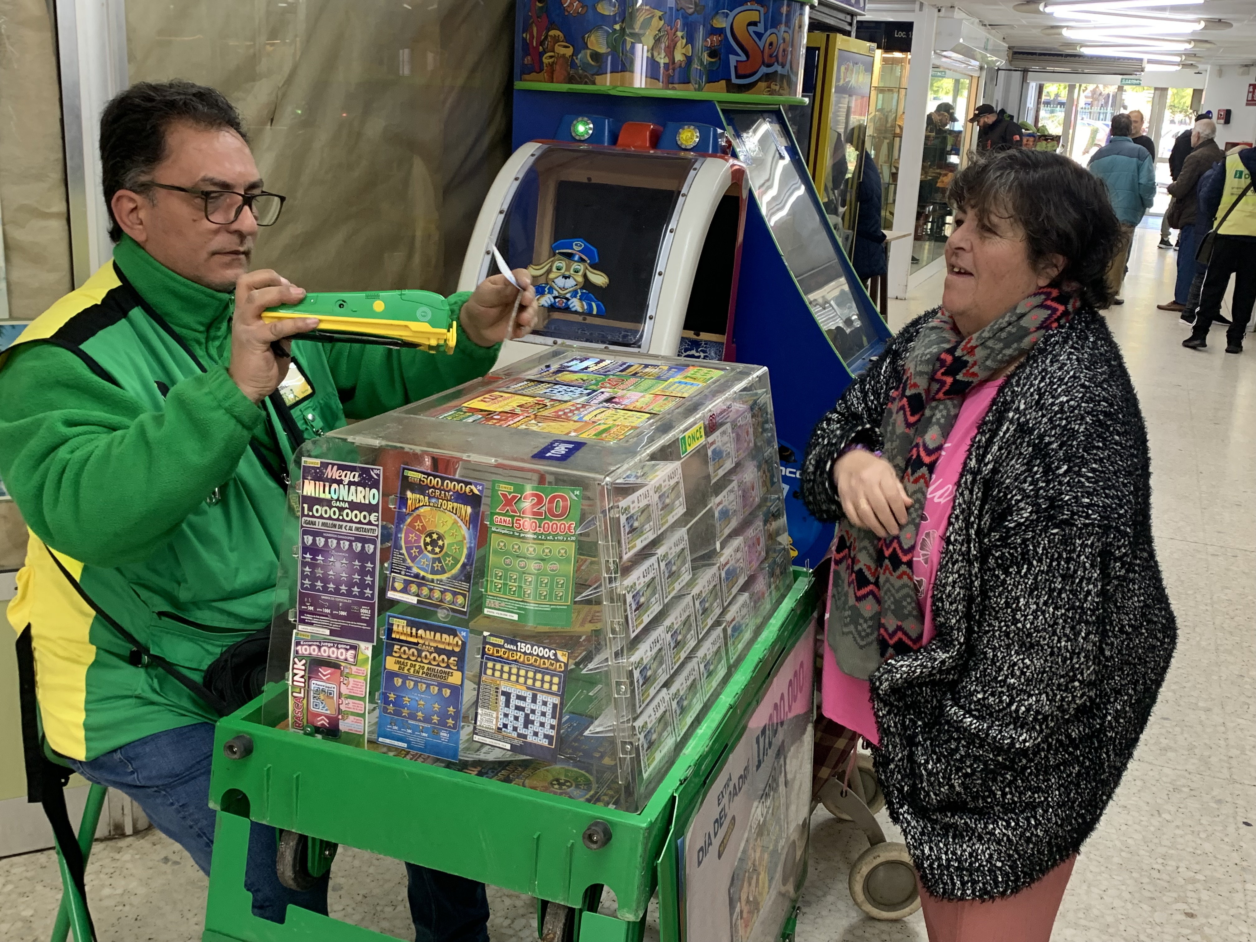 Nicolás Piza vendiendo cupones a una clienta en CencoSur, el pasaje comercial de Las Tres Mil