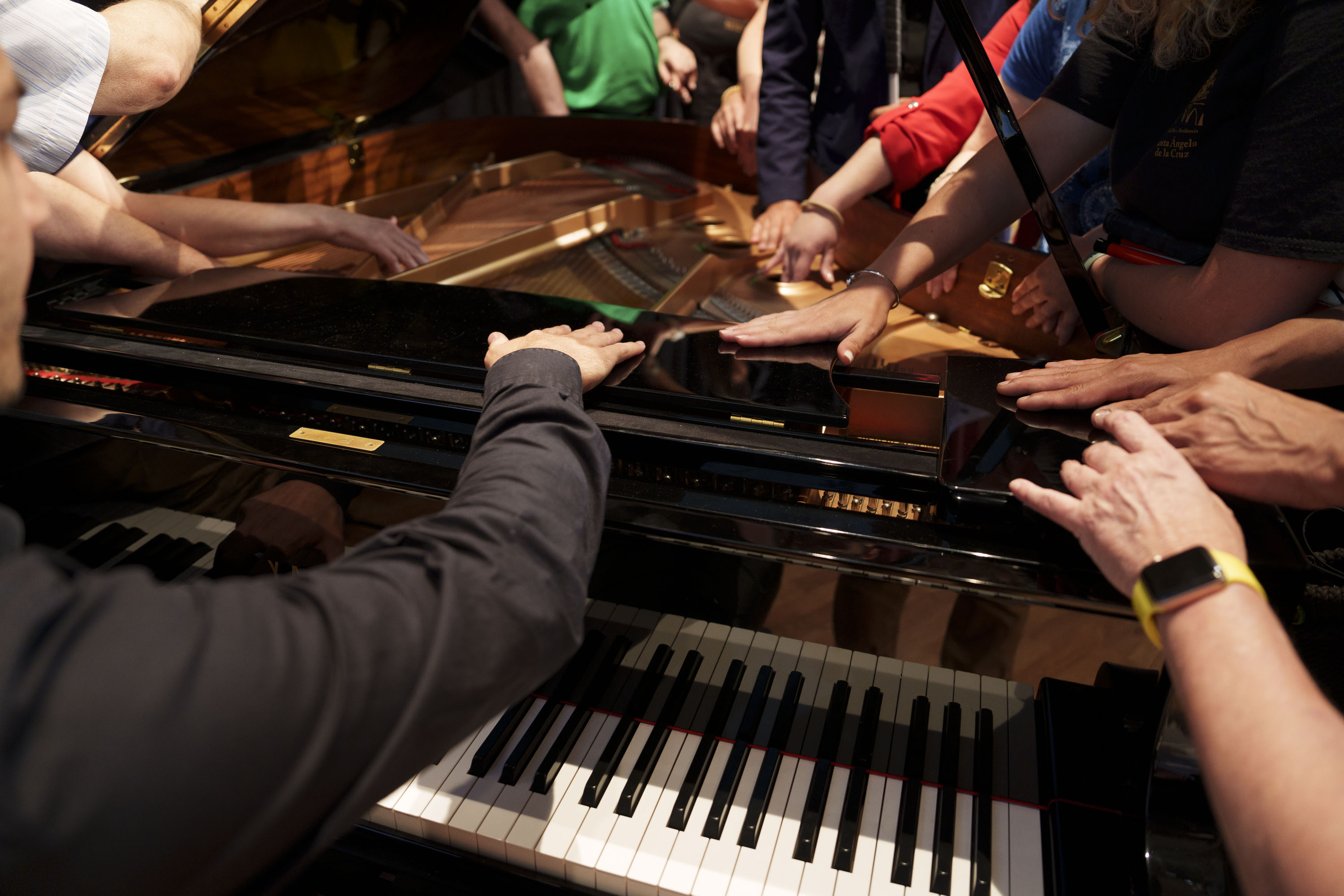 El pianista Víctor Gómez enseñando a los afiliados con sordoceguera el interior del piano