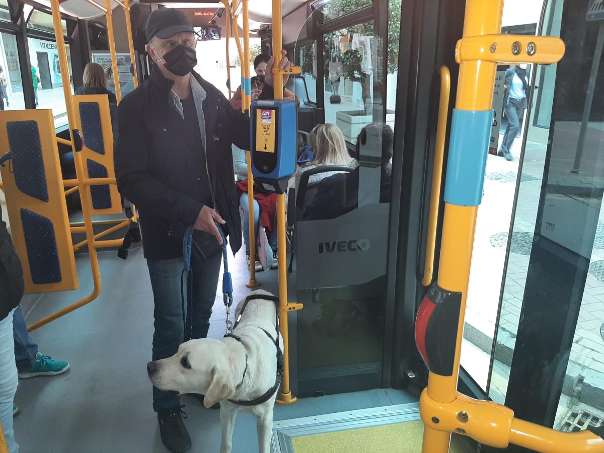 Carlos Fernández y su perro guía en el interior de un autobús de Málaga