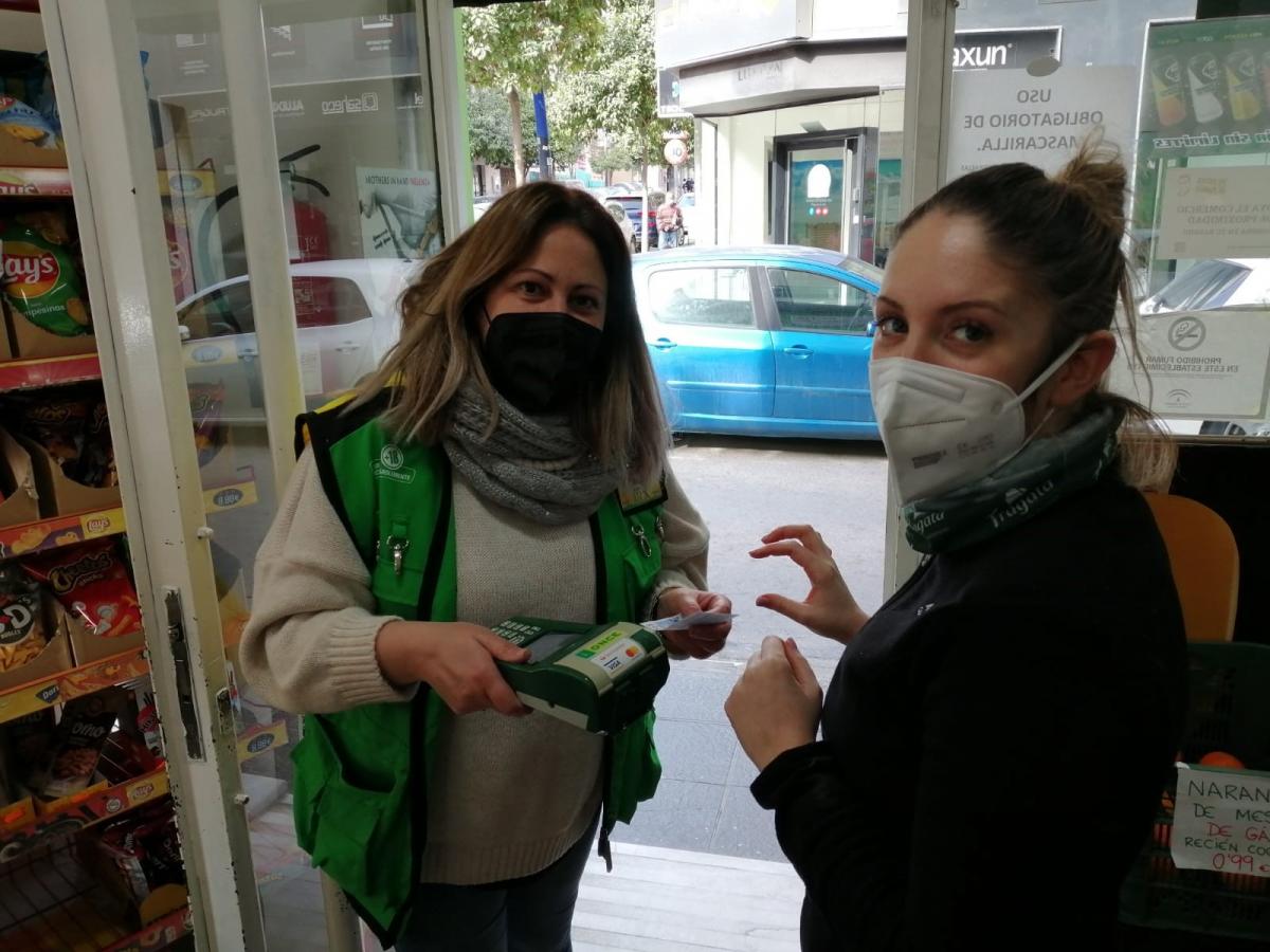 Francisca Purificación Garrido, vendedora de la ONCE en Almería, vendiendo un cupón a una clienta a través del TPV