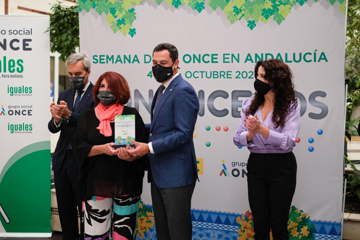 El presidente de la Junta entrega el premio como ganadora del lema de la Semana ONCE a la onubense Teresa Camero