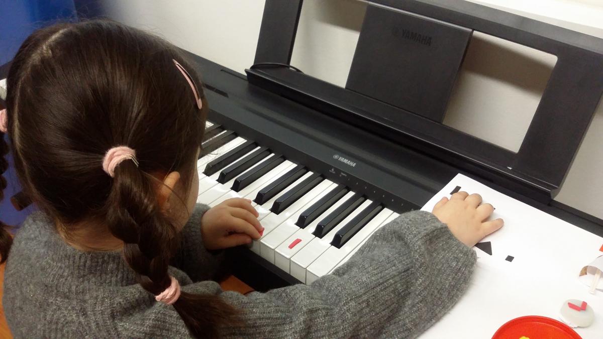 Una alumna toca el piano en el taller de música