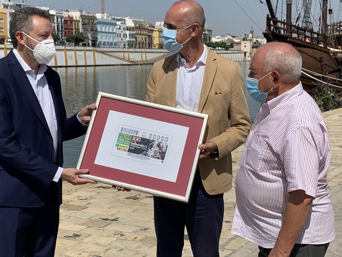 El delegado territorial entrega un cuadro con el cupón de la Bienal al primer teniente de alcalde de Sevilla y al director de la Bienal