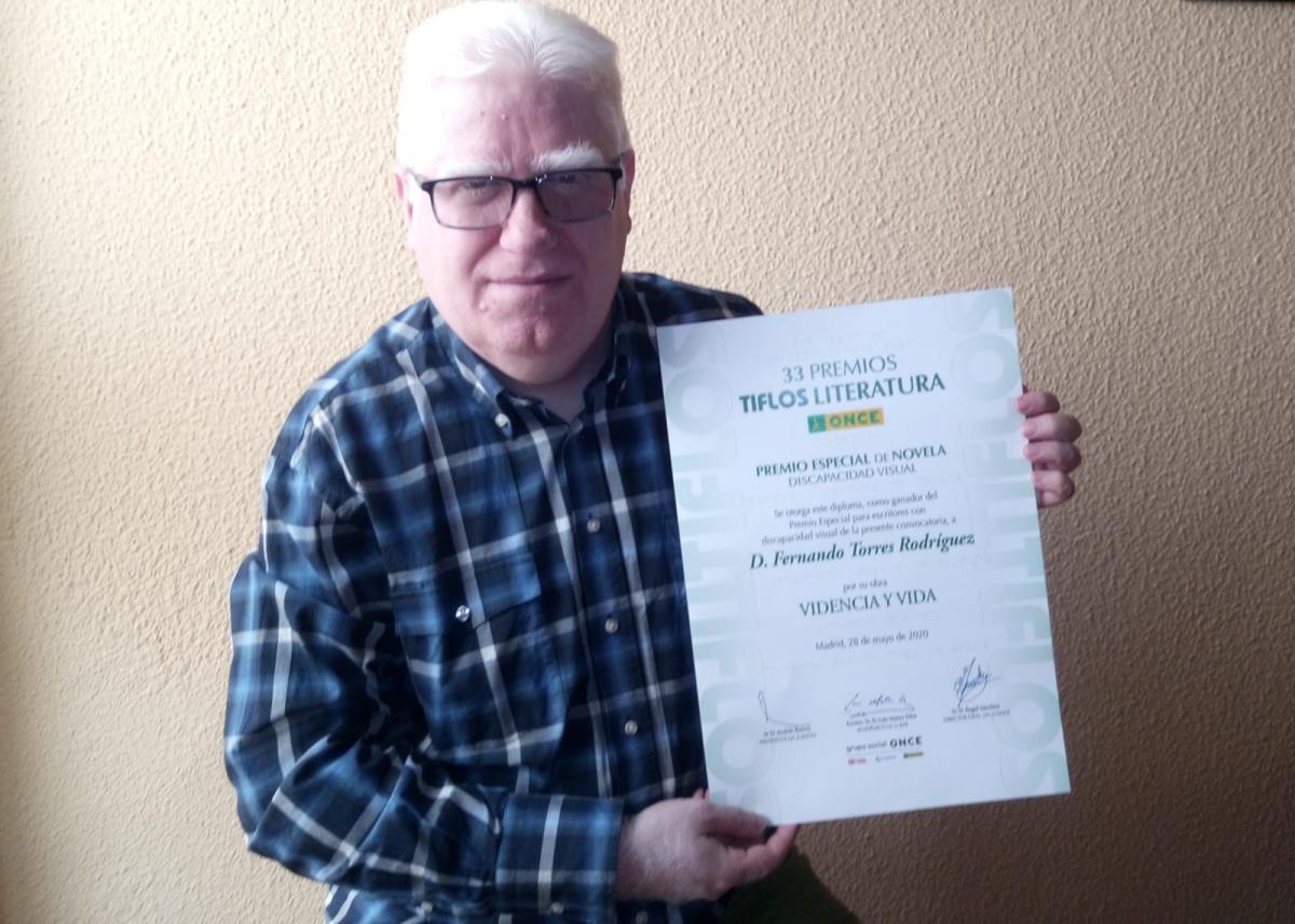 Fernando Torres muestra su premio Tiflos como novelista con discapacidad visual