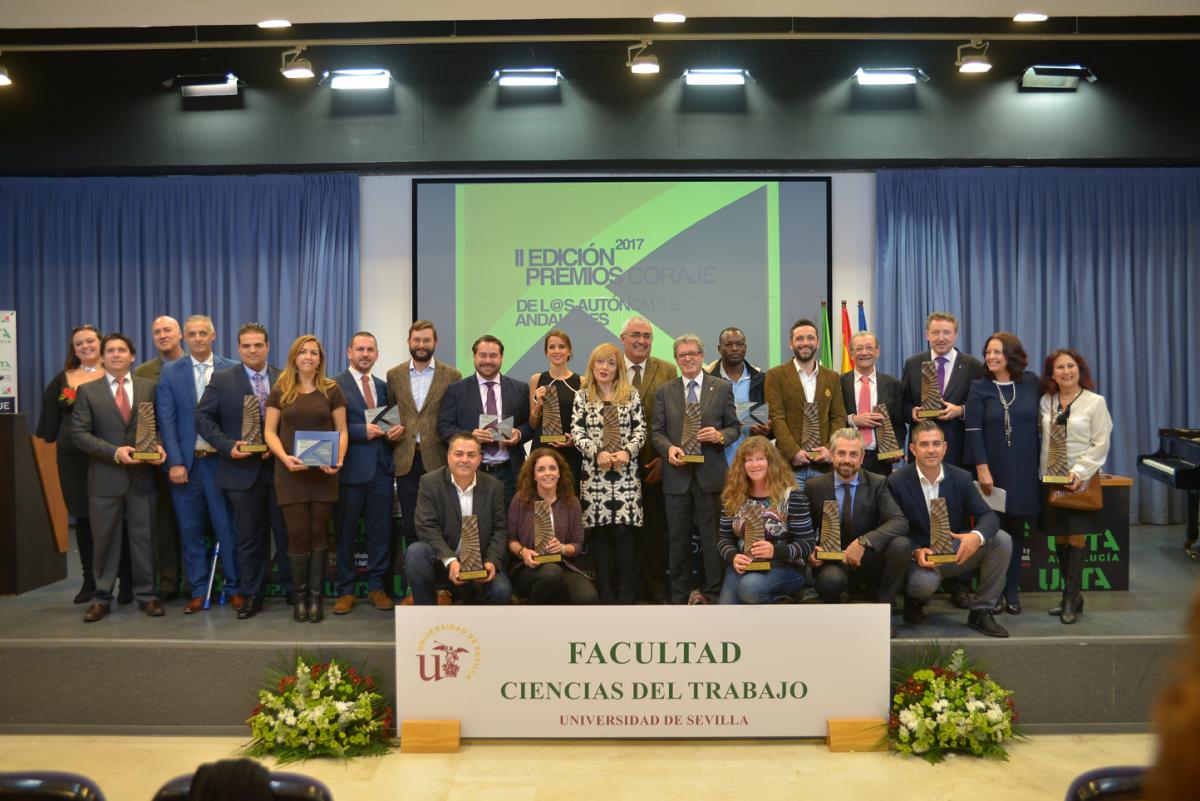 Foto de familia de todos los premiados en el escenario de la Facultad de Ciencias de Trabajo de la Universidad de Sevilla