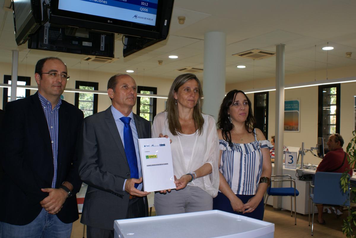 Nicolás Vargas y los representantes municipales muestran el catálogo en braille editado por la ONCE para Aguas de Huelva