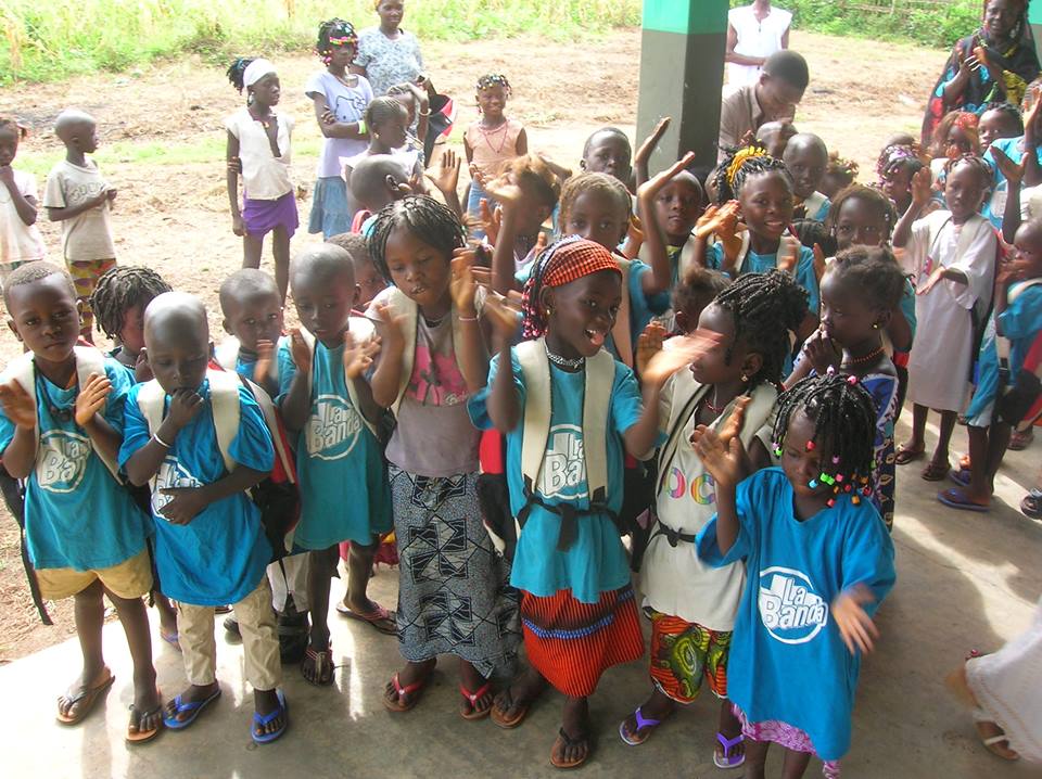 Lo niños del poblado de Laovo con sus mochilas de la ONCE al hombro