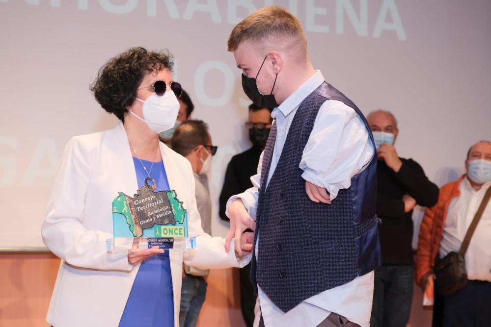 La presidenta del Consejo Territorial, Isabel Viruet, entrega el primer premio en la modalidad de solista a Pepe García