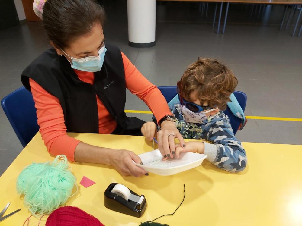 Alumno y maestra en otro trabajo de manuallidades