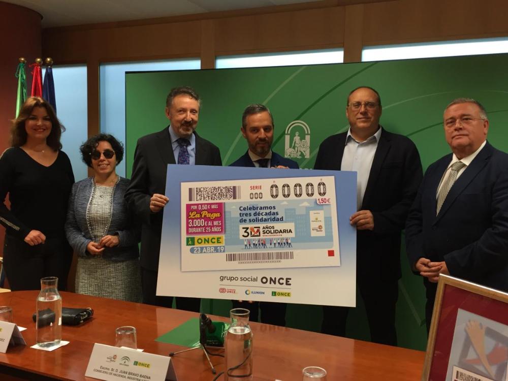 Los responsables de la Mesa del Tercer Sector con el consejero de Hacienda mostrando la imagen del cupón del 23 de abril dedicado a la X Solidaria