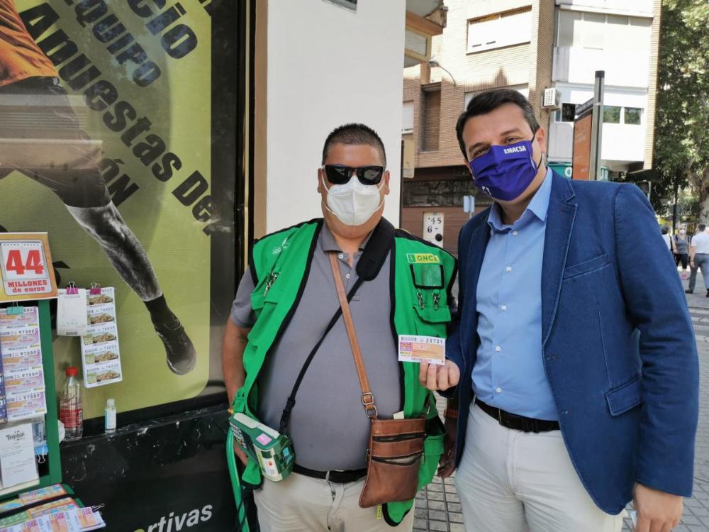 El alcalde de Córdoba, José María Bellido, compra el cupón al vendedor David Carrasco en la calle Osario de la capital cordobesa
