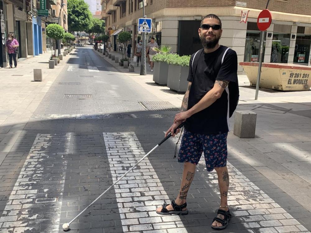 'El Ciego del Rapper' cruza con su bastón la calle Rueda López al modo de la portada de los Beatles en Abbey Road