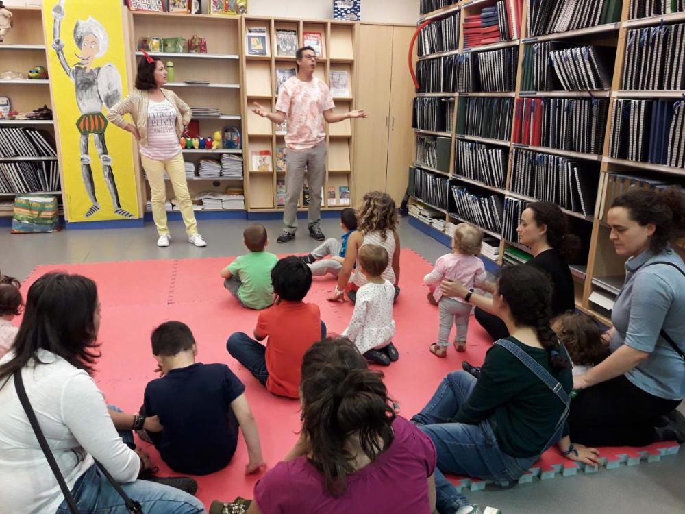 Los chavales escuchan atentos la lectura de los cuentos en la biblioteca
