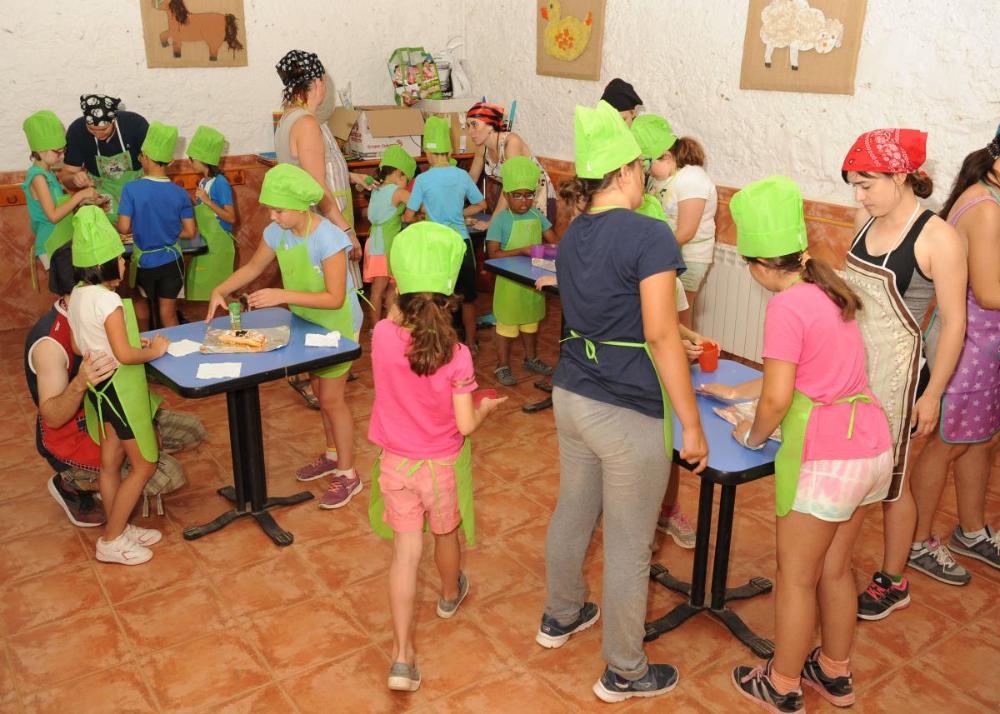 Participantes del concurso de cocina con las manos en la masa en plena faena