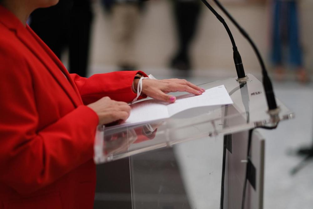 Detalle de las manos de Isabel Viruet leyendo en braille sobre el atril
