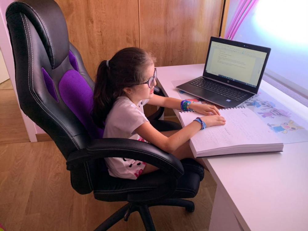 Lidia Pérez en su cuarto leyendo su redacción en braille