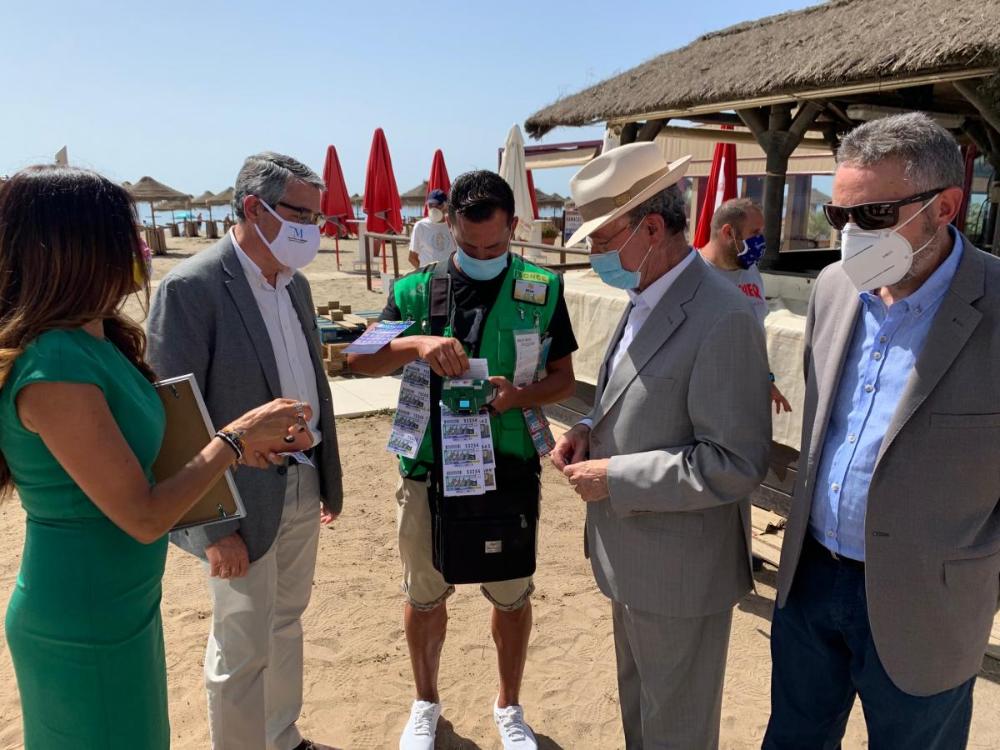 El alcalde de Málaga y el presidente de la Diputación de Málaga comprando cupones de la ONCE en presencia del delegado territorial tras la presentación del cupón dedicado al espeto de sardinas de Málaga el pasado 29 de junio