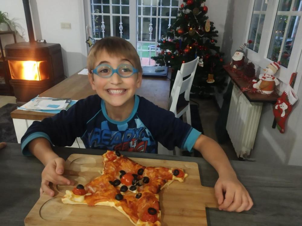 Uno de los participantes muestra orgulloso su pizza en forma de estrella