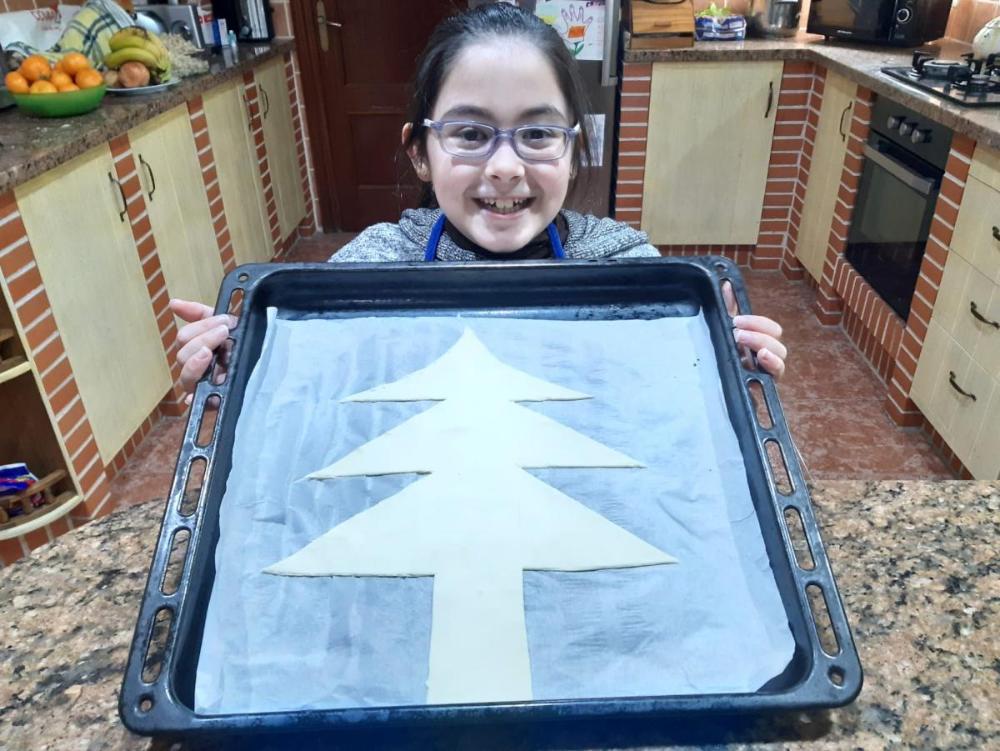 Otra alumna enseña su galleta en forma de árbol