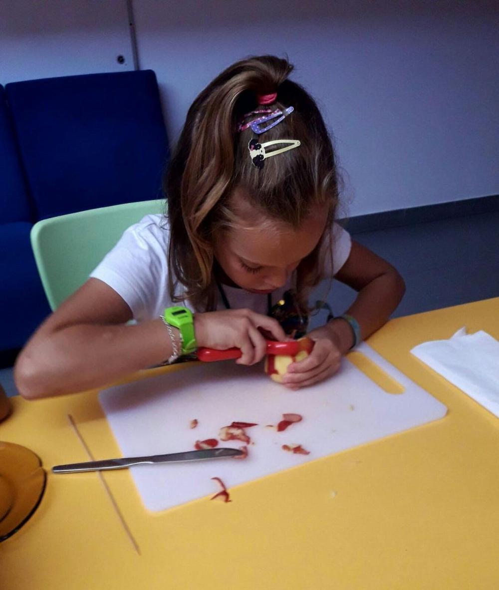 Una alumna preparando su merienda pelando su manzana