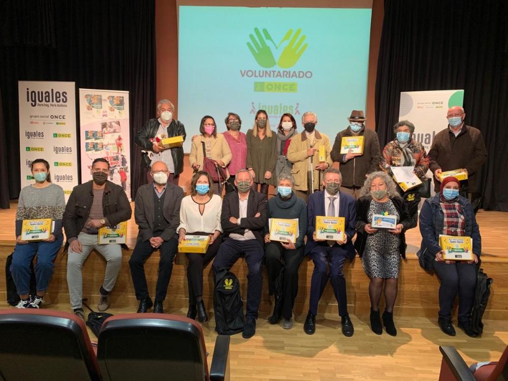 Foto de familia de los voluntarios de Sevilla tras el acto en la Delegación Territorial