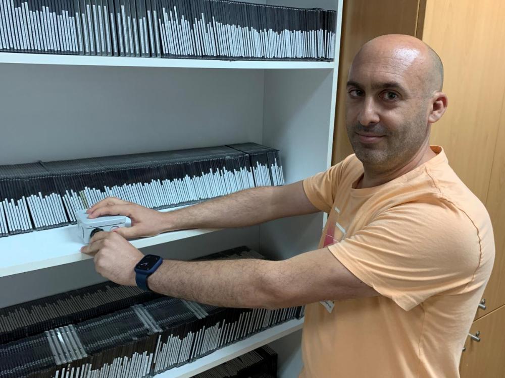 Juan Antonio Sánchez manipulando una baliza de señalización acústica portátil en la Tifloteca de la ONCE de Almería