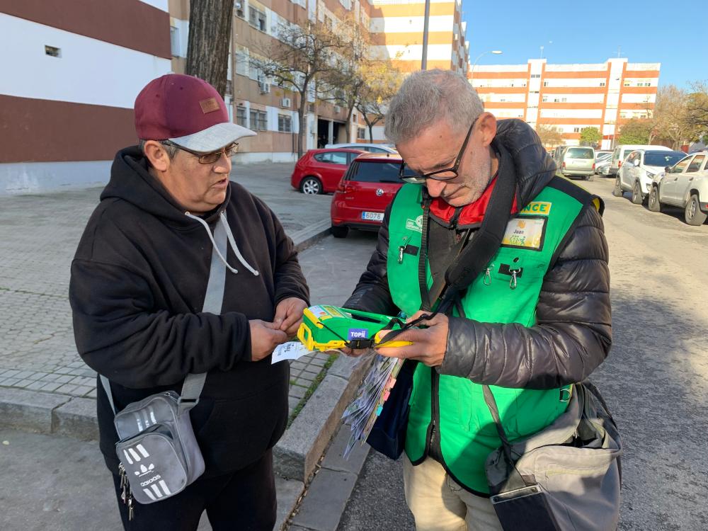 Juan Rodríguez comprueba un cupón premiado a un cliente