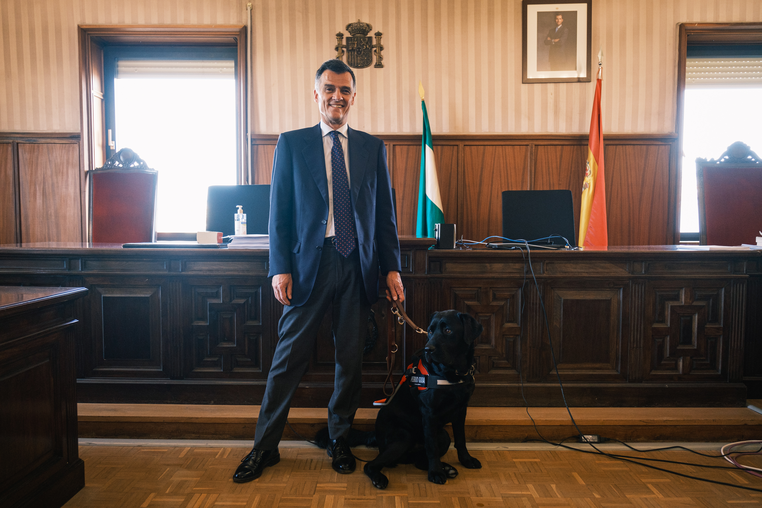 El magistrado Luis de Oro-Pulido con su perro guía Pusky en una de las Salas de Vistas de la Audiencia de Sevilla