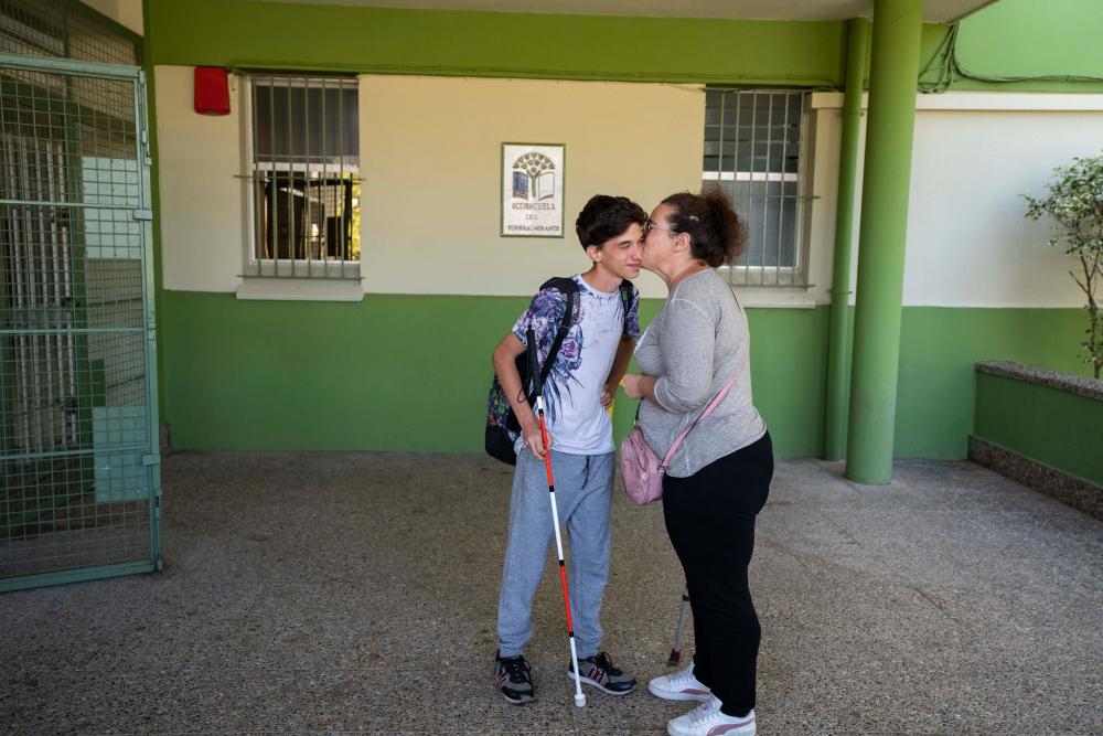 Antonio recibe un beso de su madre a la entrada del Instituto
