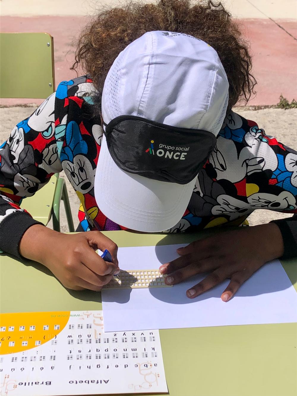 Niña escribiendo en braille