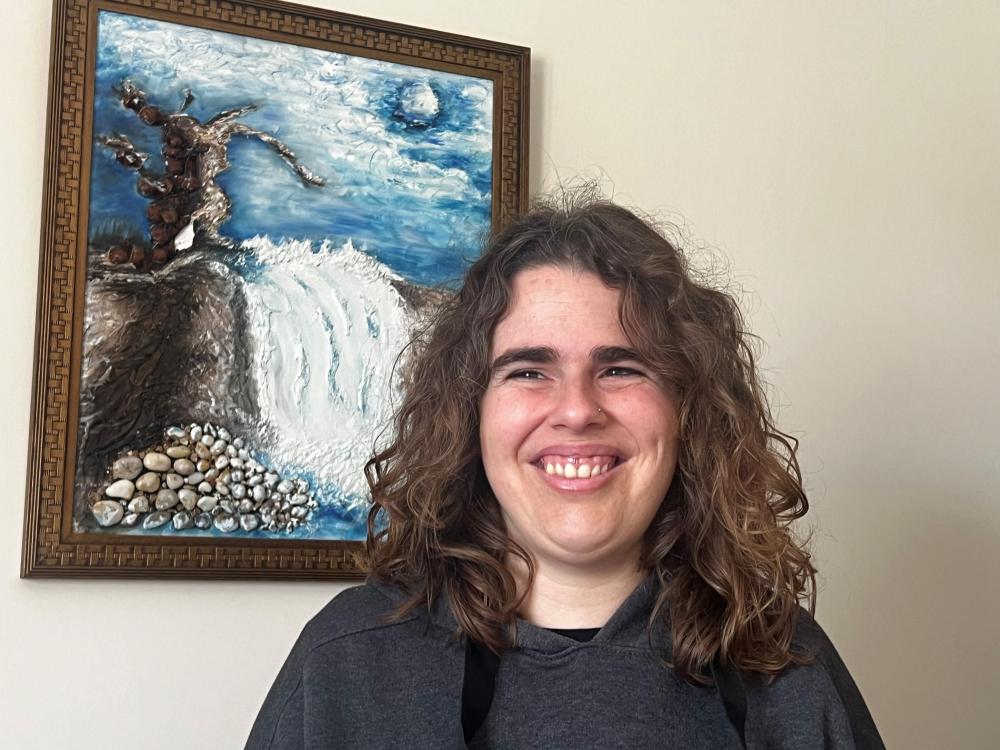 Primer plano sonriente de Aina junto a un cuadro