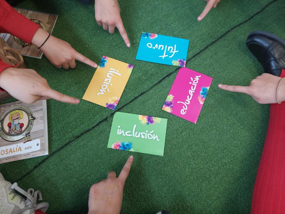 Dedos señalando tarjetones con las palabras ilusión, inclusión, futuro y educación