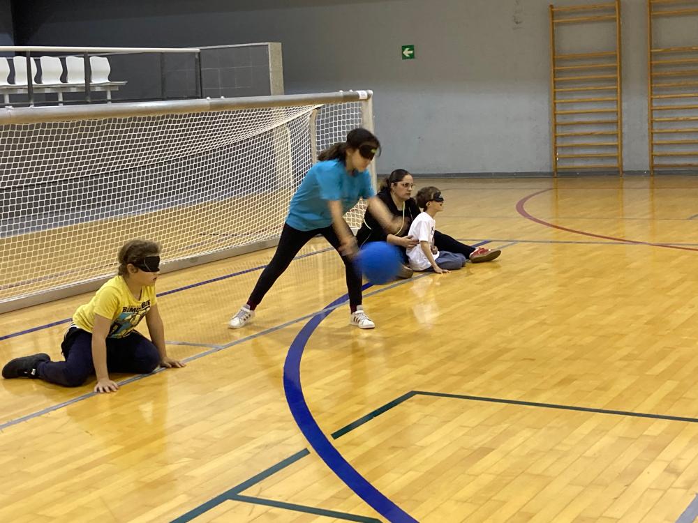 Alumnos en el taller de goalball, uno de ellos con sordoceguera, acompañado de su mediadora