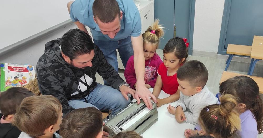 Niños alrededor de una máquina Perkins