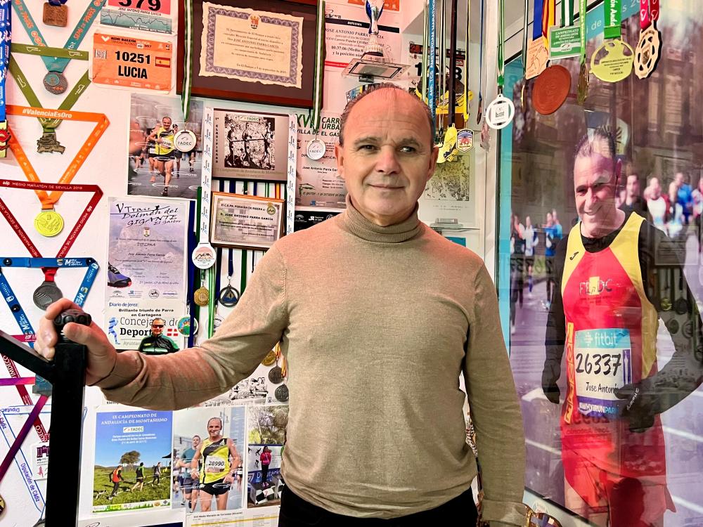 Parra en una pared llena de sus trofeos, diplomas y medallas