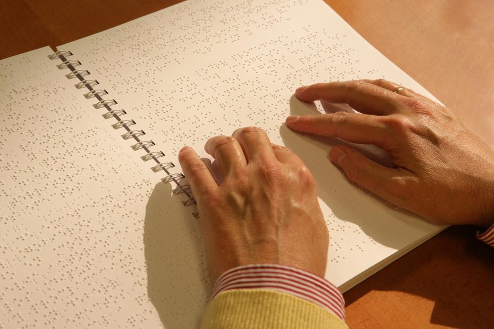 Las manos de una persona leen un libro en braille