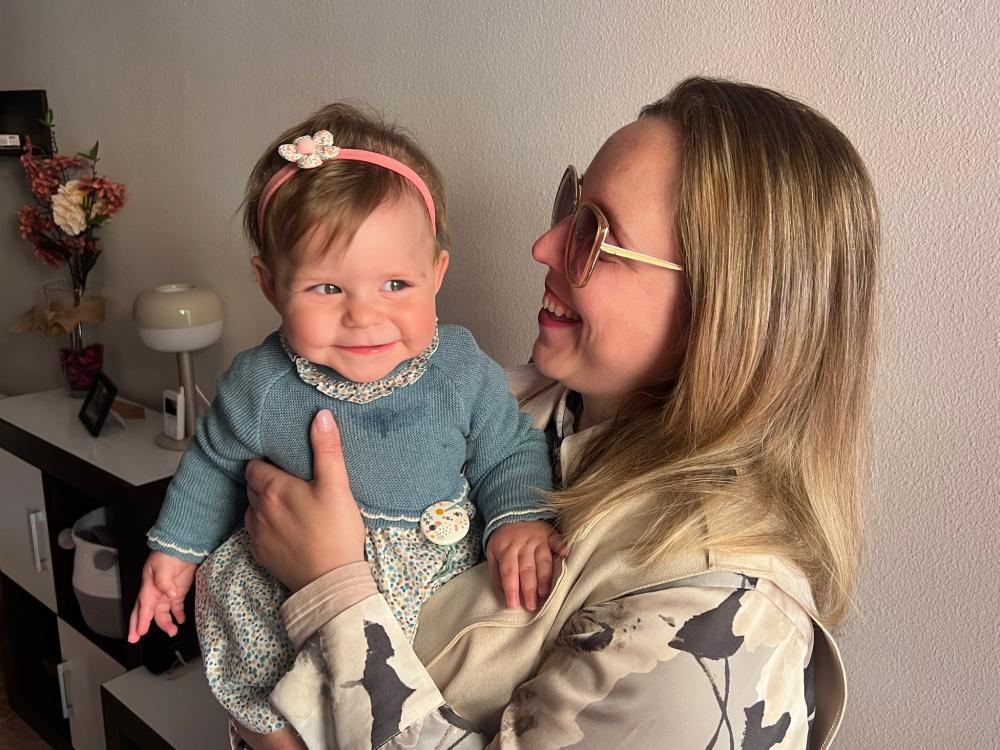 Anabel sonriente sosteniendo a Alba