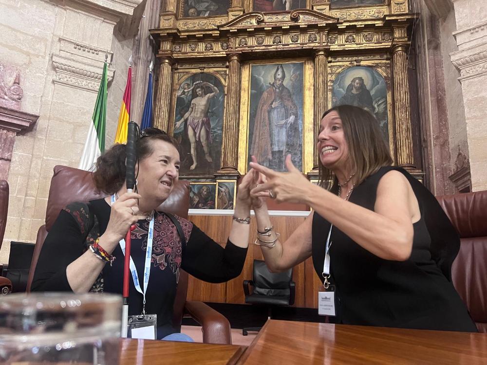 Afiliado sordociego en el palco del Parlamento junto a su mediadora comunicativa