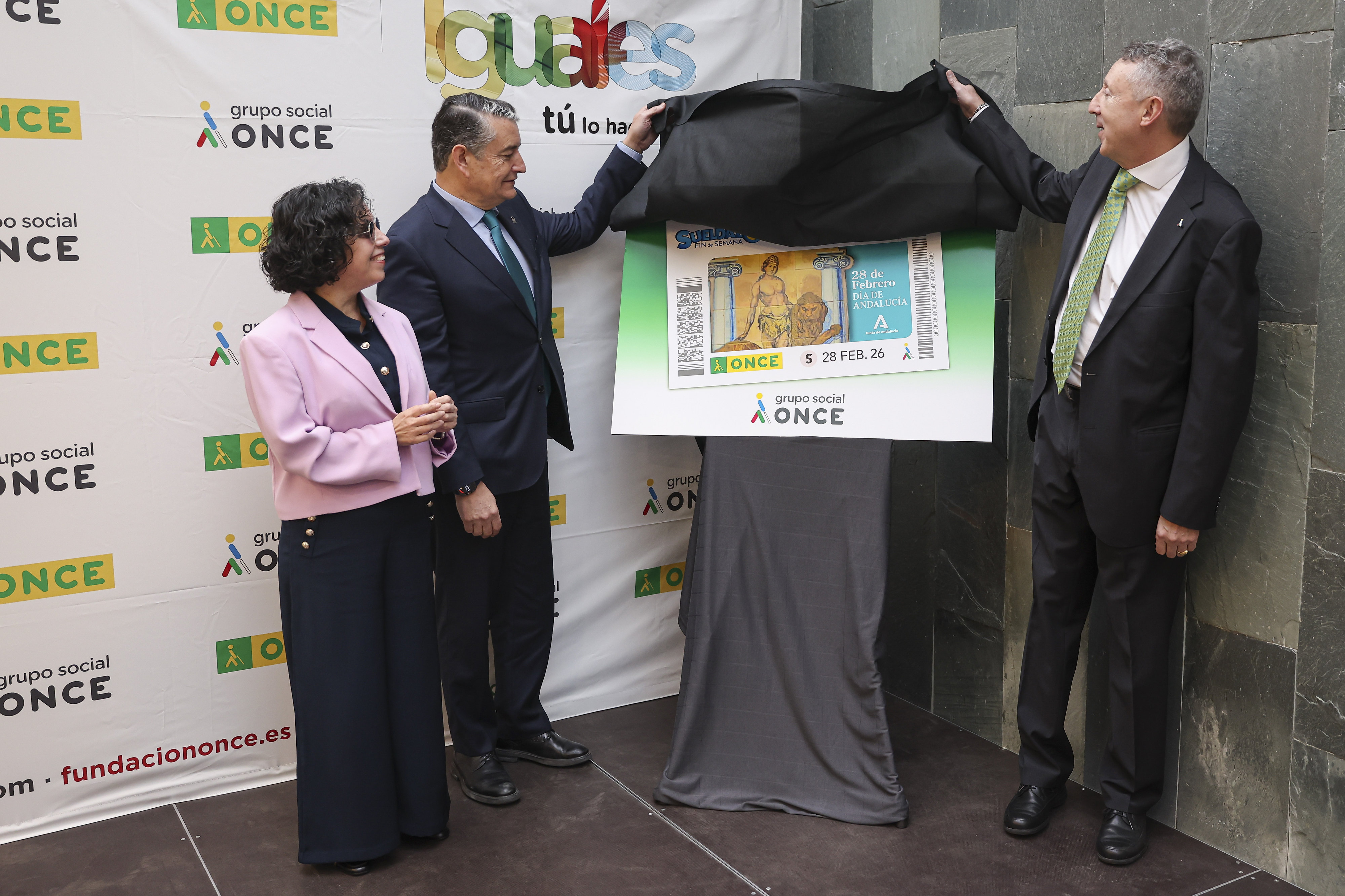 Cristobal Martínez, Isabel Viruet y Antonio Sanz descubren la imagen del cupón del Día de Andalucía