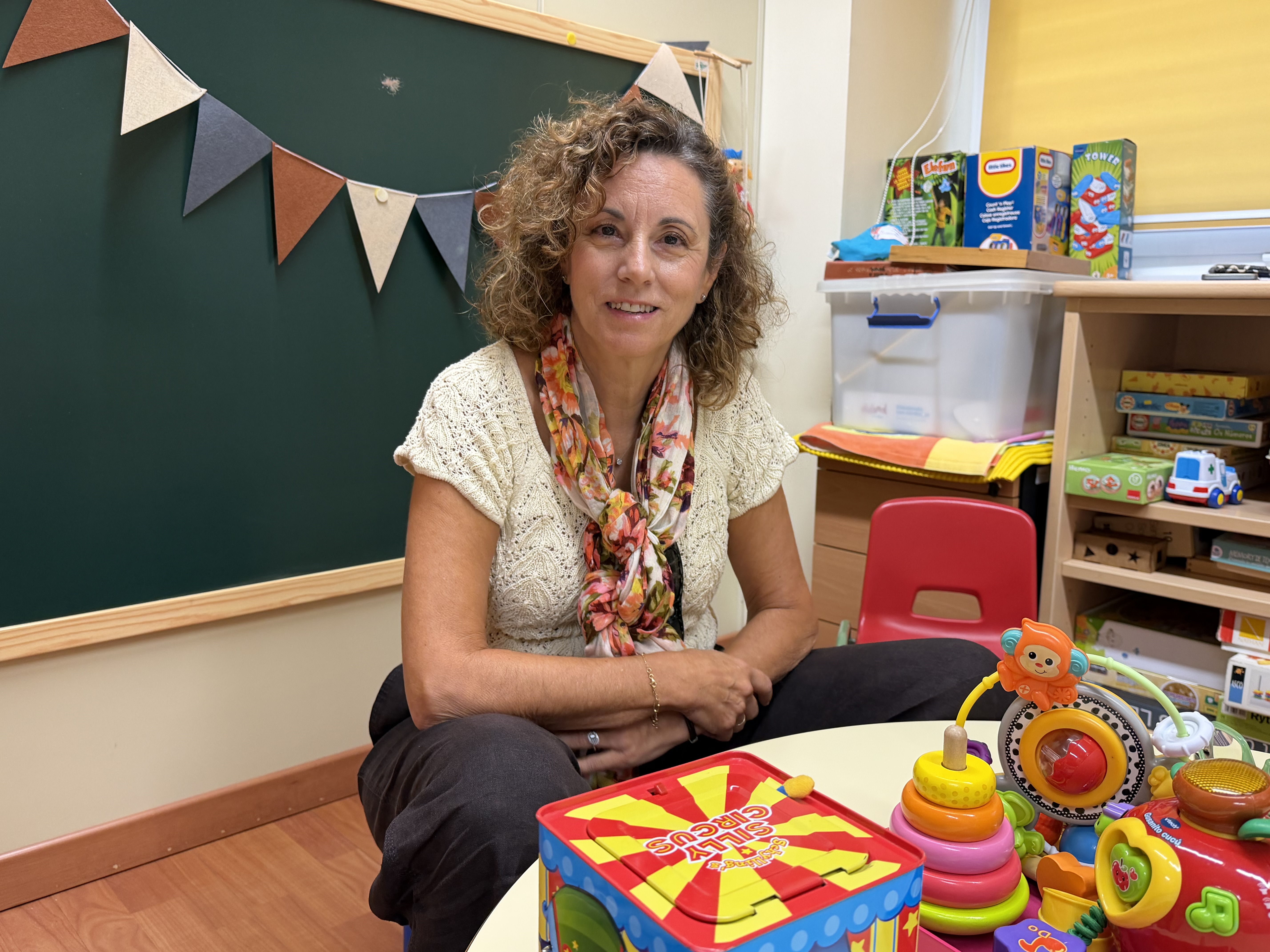 Inma Costo sentada en la mesita de los niños en el aula de Atención Temprana
