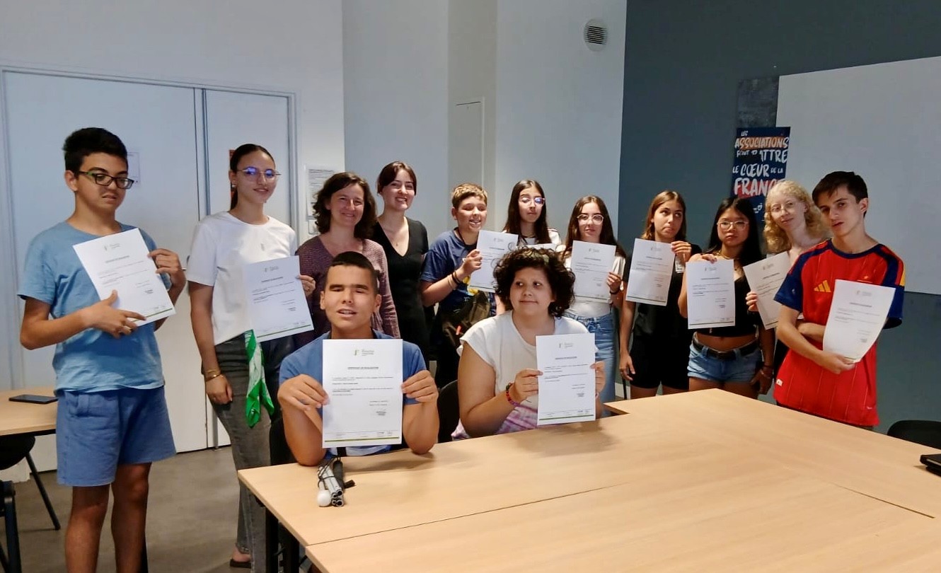 Estudiantes enseñando su diploma con los profesores de Francés