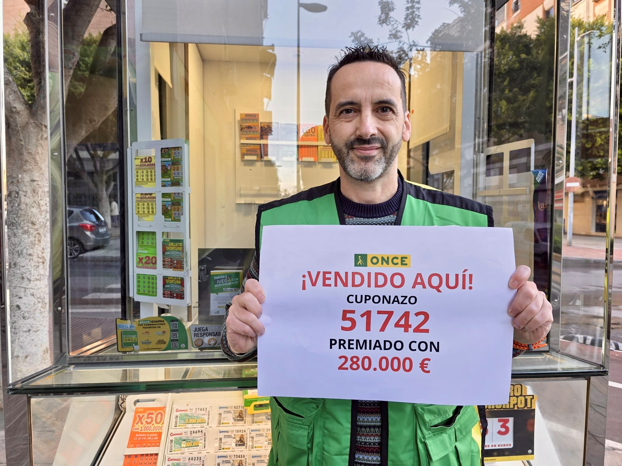Pedro Reina enseñando un cartel del premio