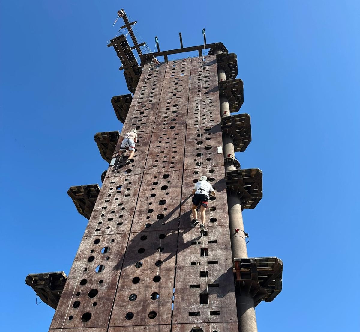 Alumno subiendo a una torre de escalada